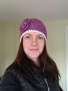 Purple crochet beanie with multi layer flower brooch and ceramic handmade button centre.