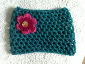 Teal coloured chunky crocheted cowl scarf with felt and sewn flower brooch.