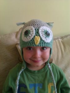Cosy grey and pale green crocheted owl hat.