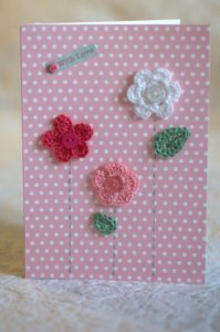 Hand made and hand stitched, pink and white crocheted flowers and green crocheted leaves greetings card and 'with love' tag on front. Left blank inside for your own message. Size w12.7 x h17.7cm