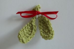 Green crocheted mistletoe, with pearl beads and red ribbon bow. 