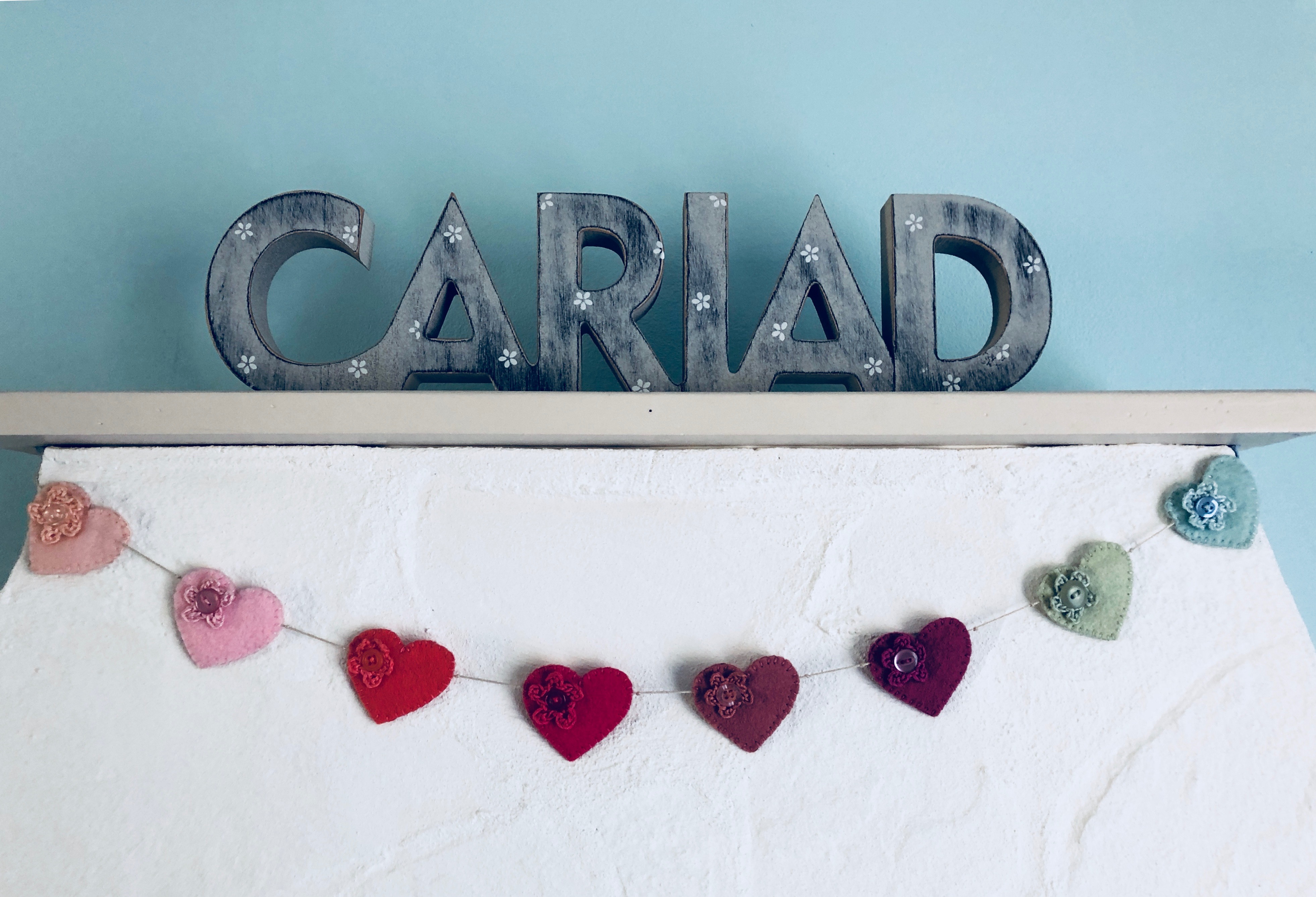 Hand stitched multi coloured felt heart garland with tiny crocheted flowers.