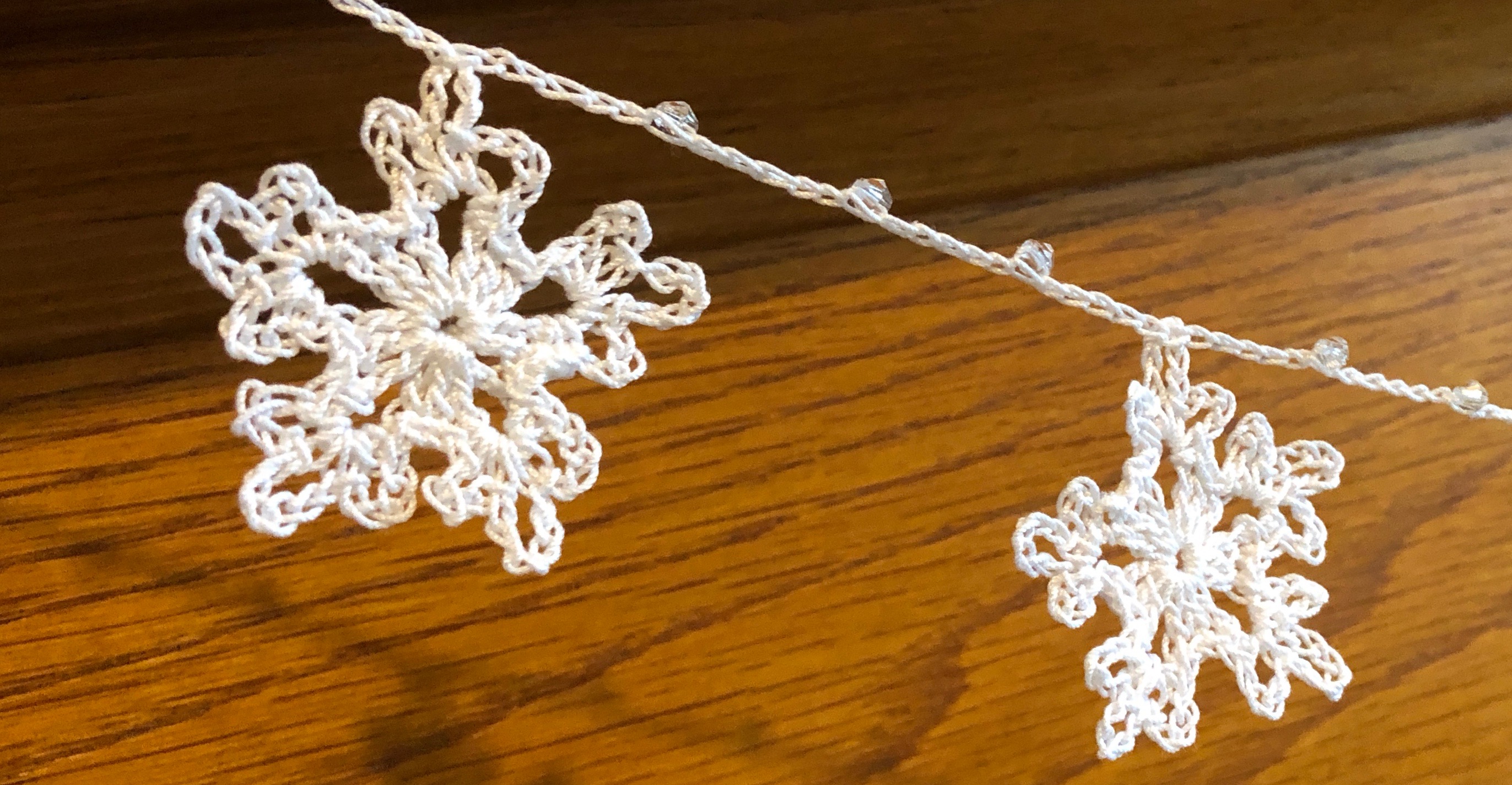 Handmade, crocheted, white cotton snowflakes and clear crystal style bead garland.