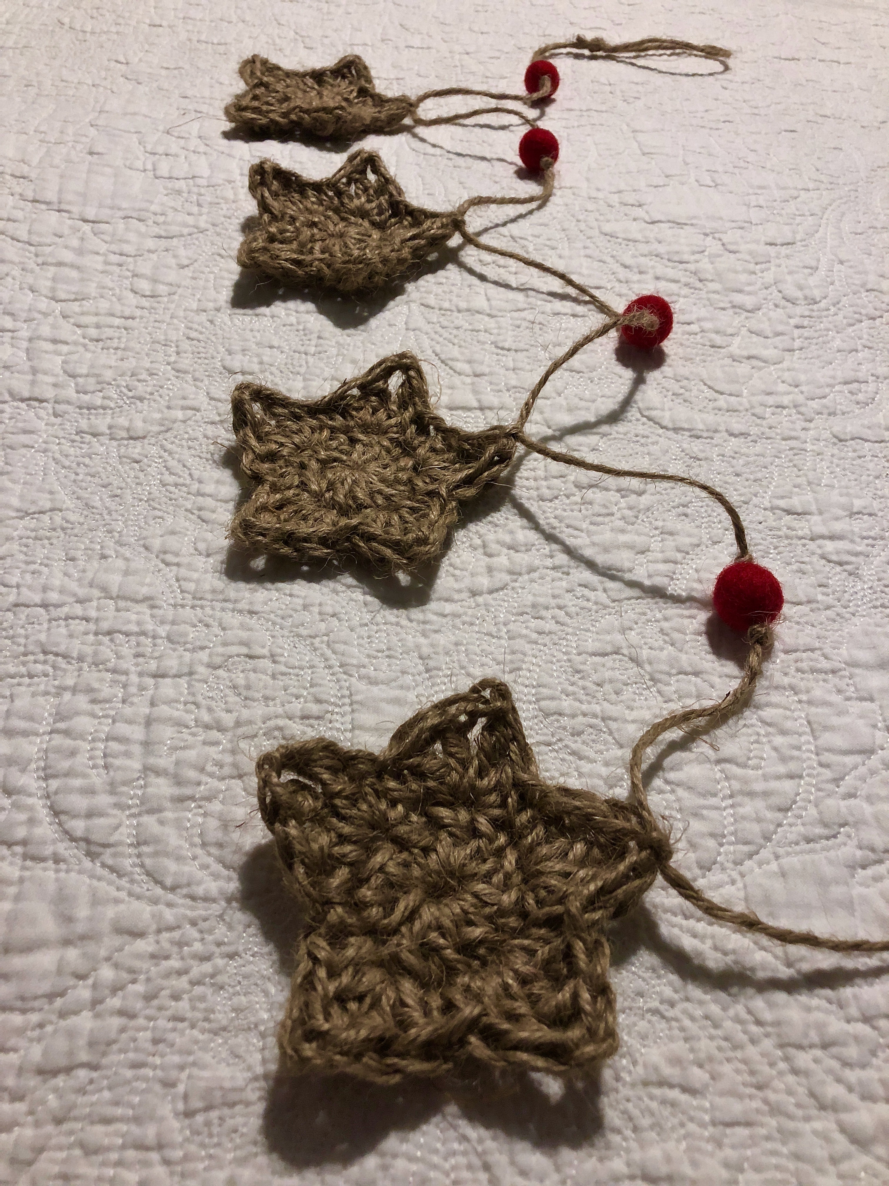 Jute twine, crocheted medium sized star and red felt pom-pom garland.