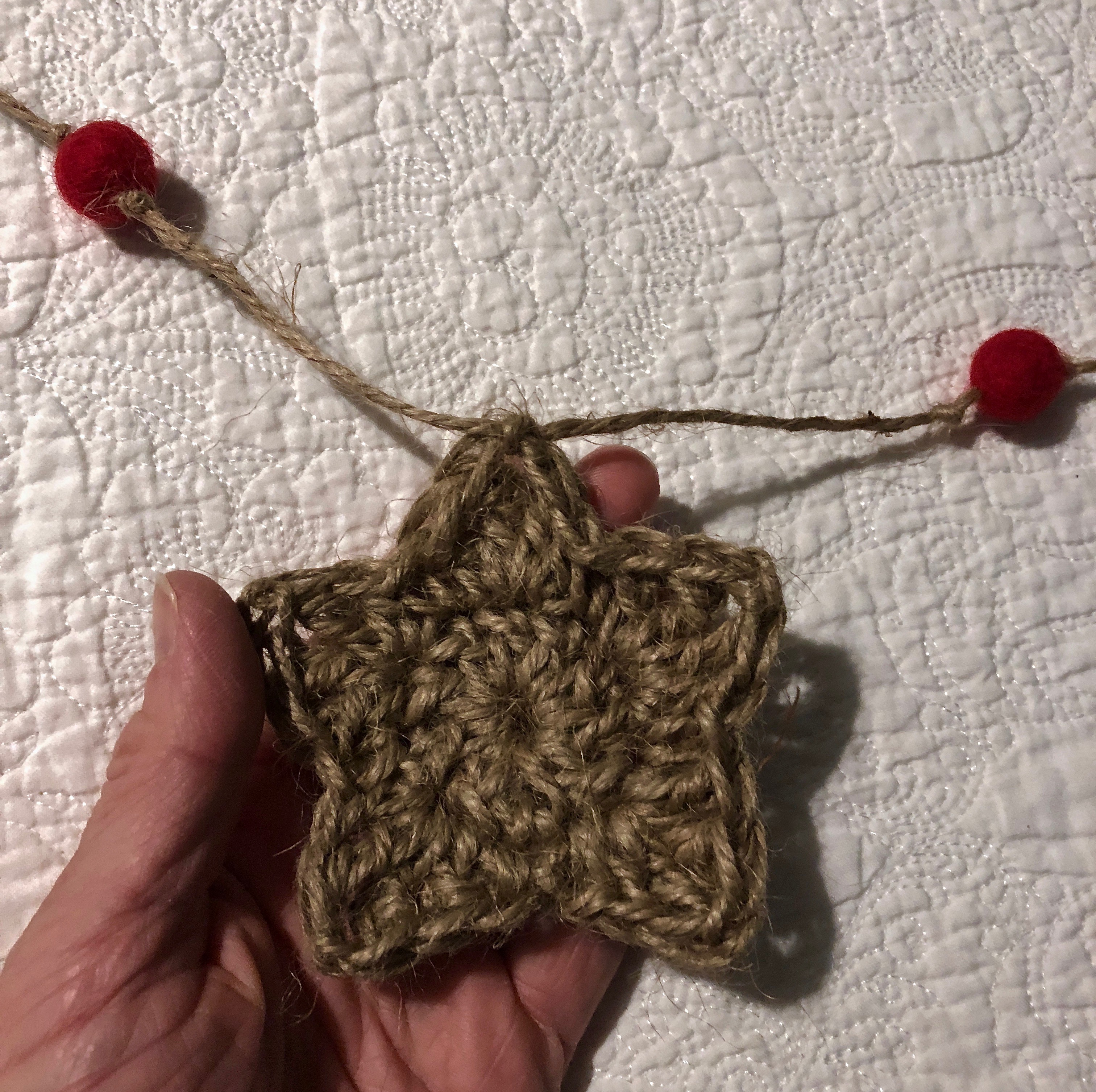 Jute twine, crocheted medium sized star and red felt pom-pom garland.