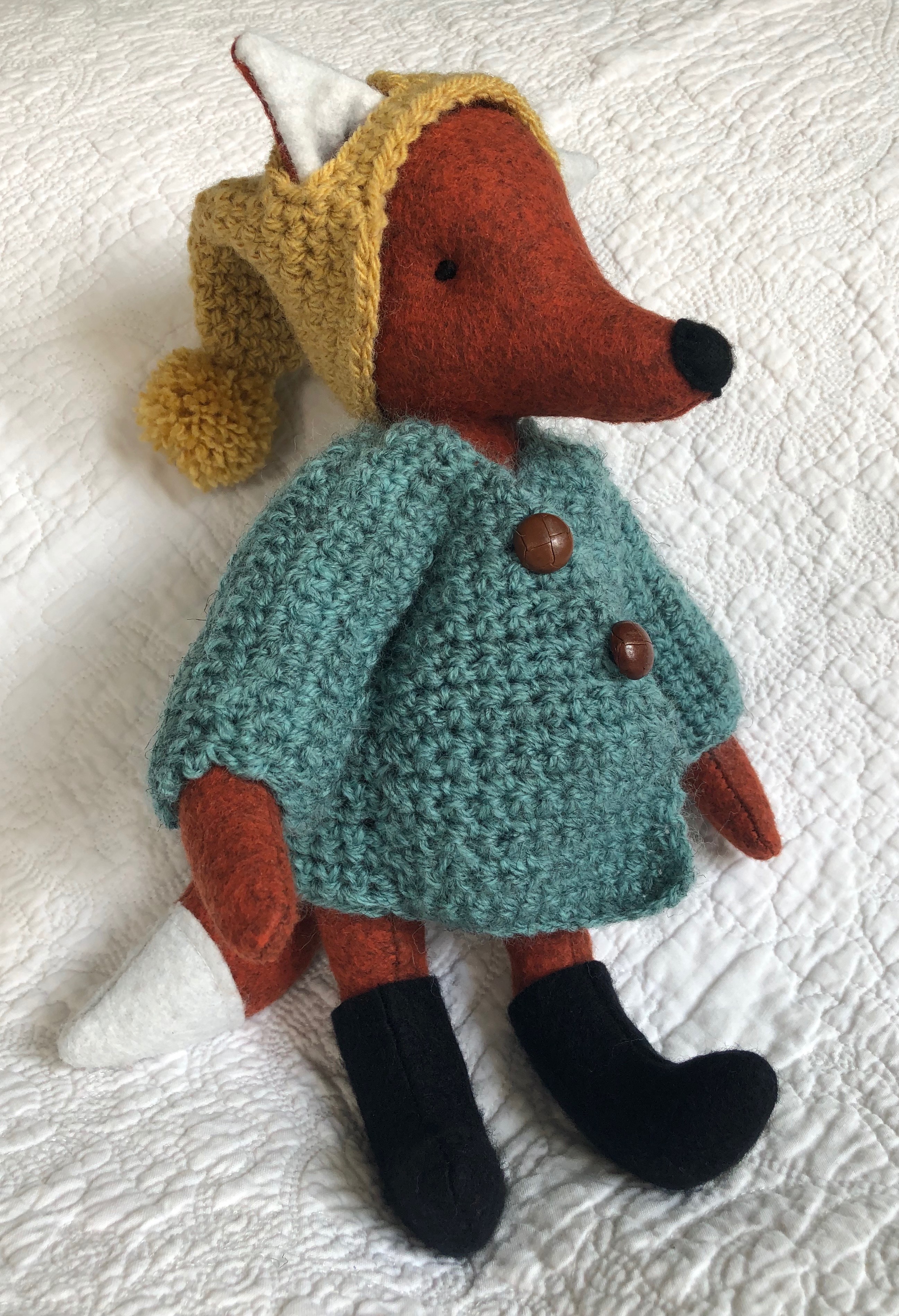 A handmade rusty brown felt fox with a green hand crocheted jacket, mustard yellow bobble hated little black felt boots. Fox pattern by Simone Gooding, crocheted clothes designed and made by me.