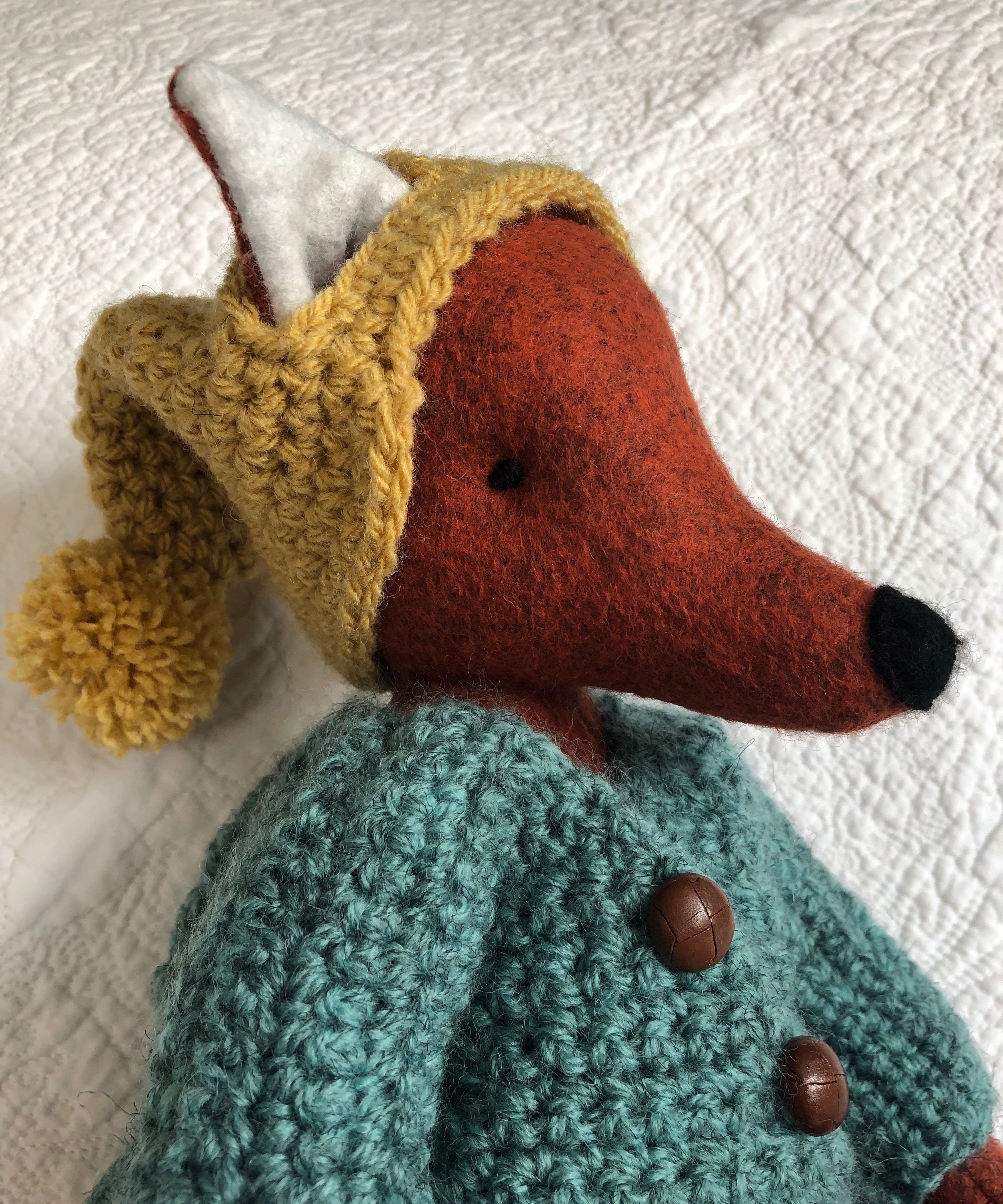 A handmade rusty brown felt fox with a green hand crocheted jacket, mustard yellow bobble hated little black felt boots. Fox pattern by Simone Gooding, crocheted clothes designed and made by me.