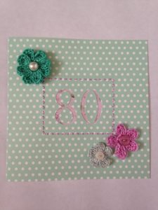 Hand crocheted and hand sewn, flowers and buttons 80th birthday card.