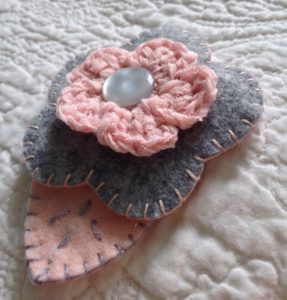Grey and pale pink hand sewn felt and crocheted flower brooch.