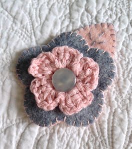 Grey and pale pink hand sewn felt and crocheted flower brooch.