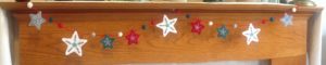 Scandi inspired, red green and white felt, hand embroidered star garland with felt pompoms.
