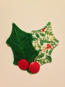 Felt and fabric, hand stitched brooch with red button berries.