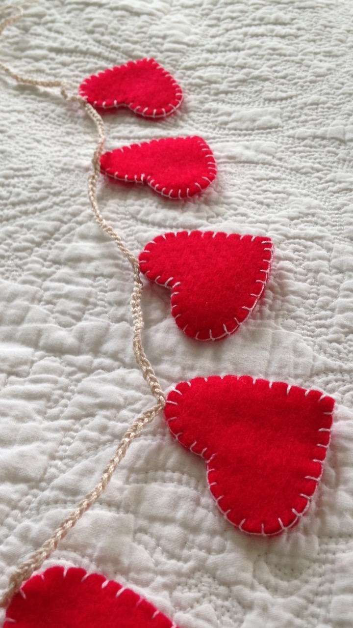 A garland of red, hand stitched, felt hearts.