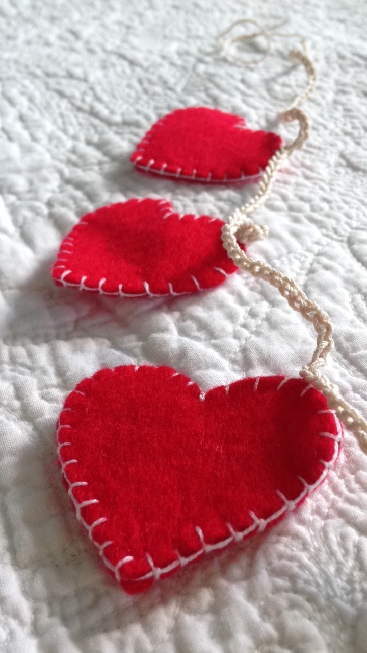 A garland of red, hand stitched, felt hearts.