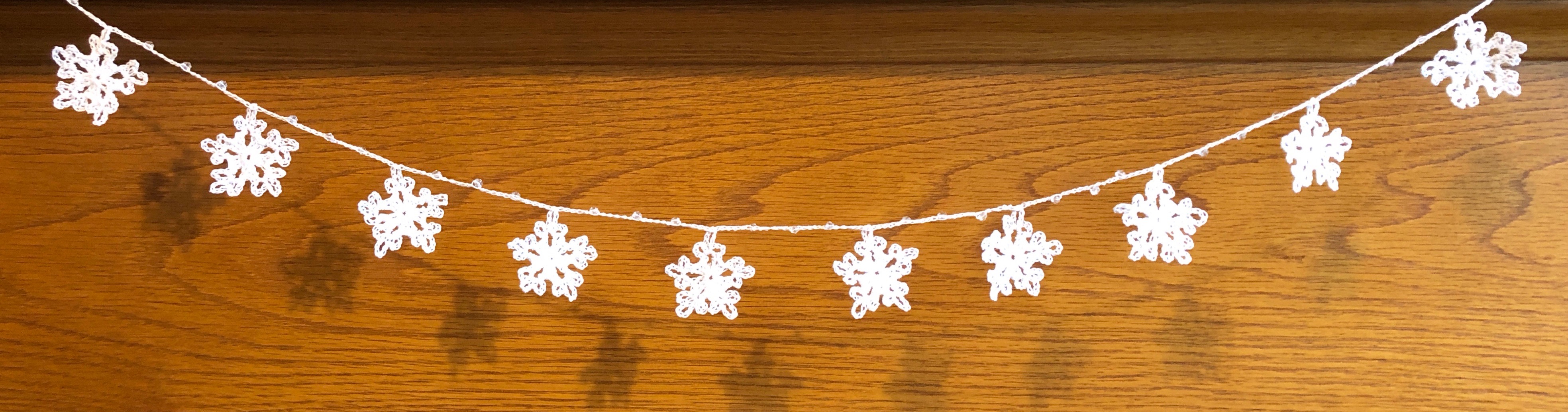 Handmade, crocheted, white cotton snowflakes and clear crystal style bead garland.