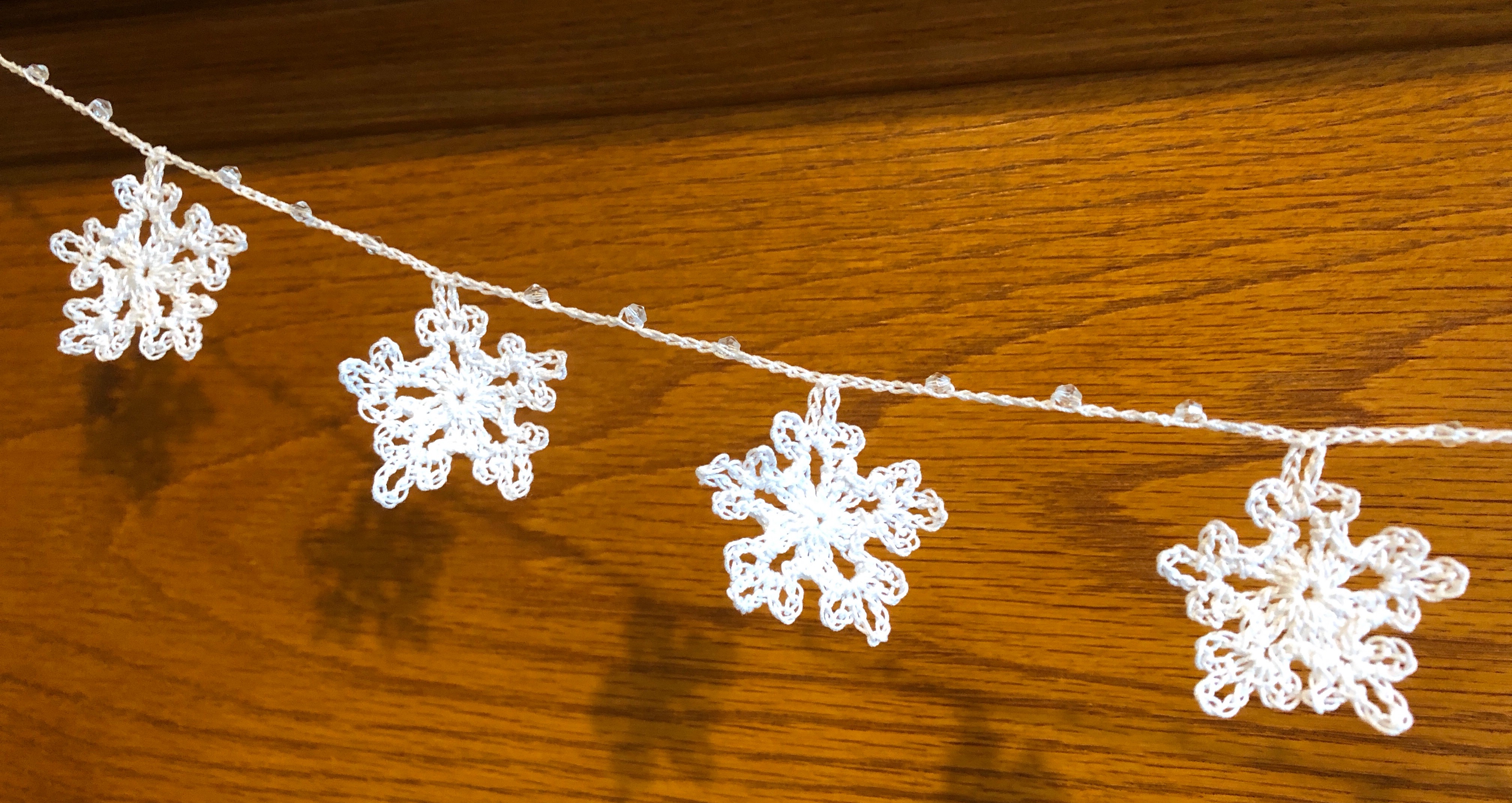 Handmade, crocheted, white cotton snowflakes and clear crystal style bead garland.