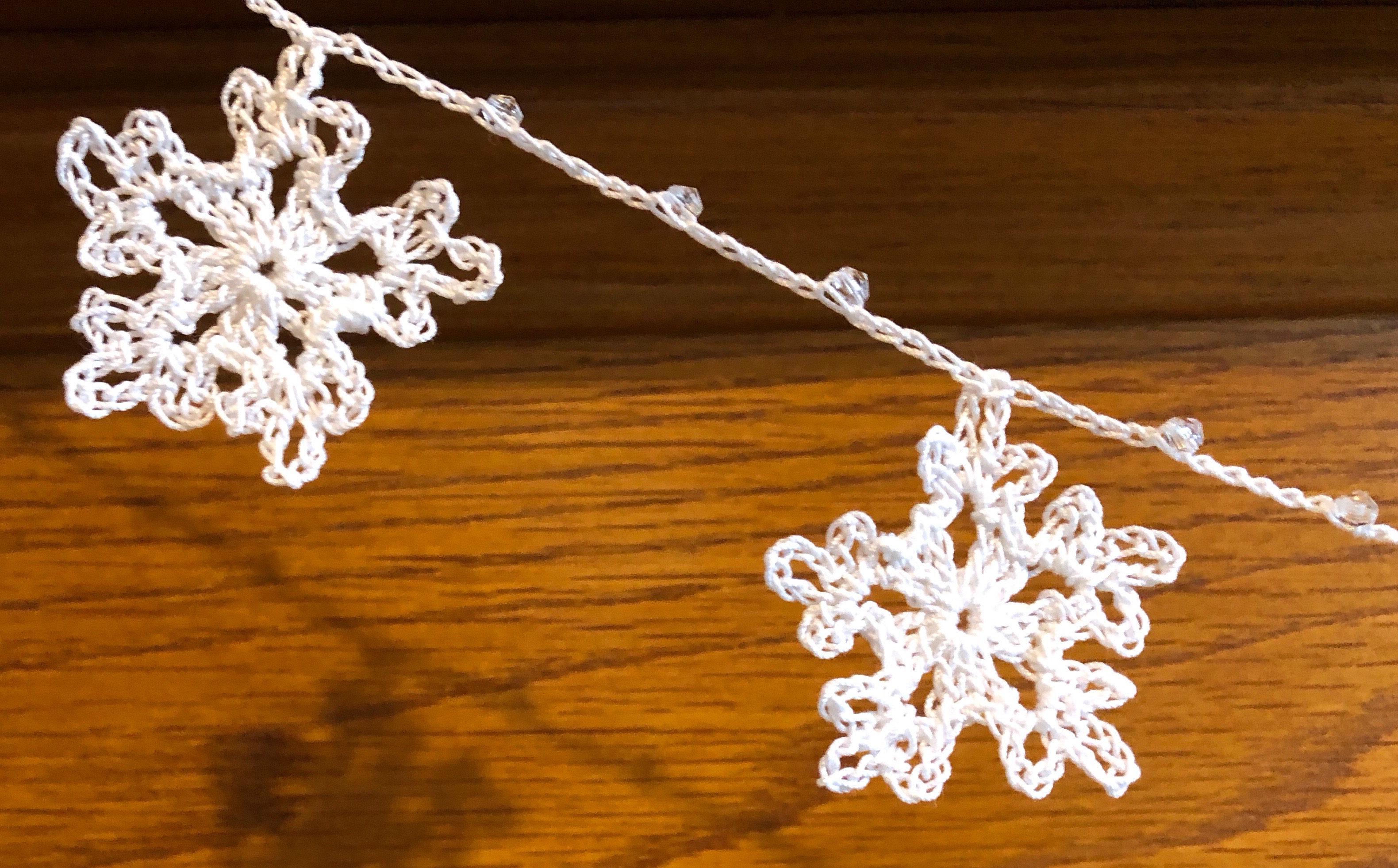 Handmade, crocheted, white cotton snowflakes and clear crystal style bead garland.