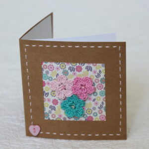 Posy of 3 crocheted flowers with hand stitched border on a small brown card (approximate size 10 x 10 cm)with blank white insert. Brown envelope included.