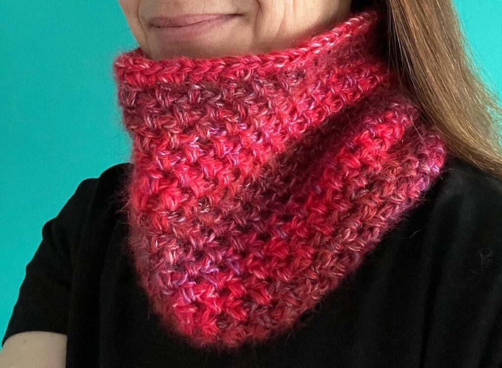 A handmade, crocheted neck warmer, in a variegated colour combination of red and purple tones. Made using a mix of two lightweight yet warm yarns. Acrylic/Wool/Mohair mix.