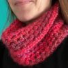 A handmade, crocheted neck warmer, in a variegated colour combination of red and purple tones. Made using a mix of two lightweight yet warm yarns. Acrylic/Wool/Mohair mix.