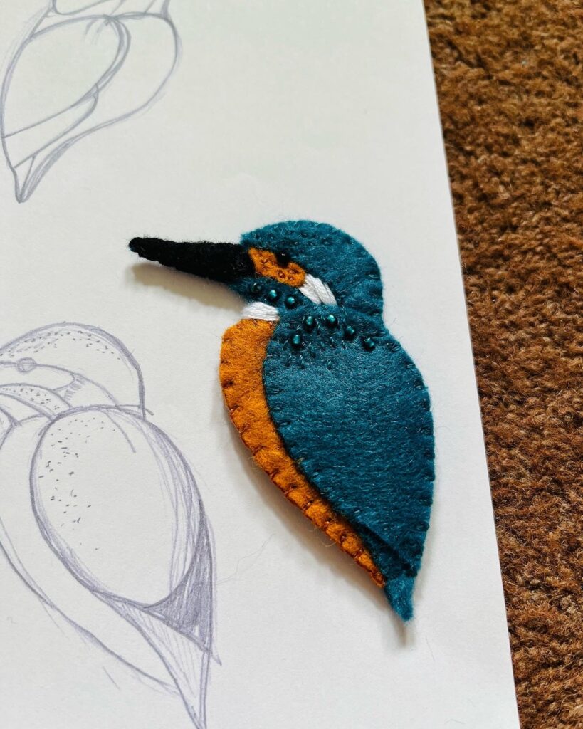 A Kingfisher brooch, handmade in felt and embellished with glass beads and hand embroidery.