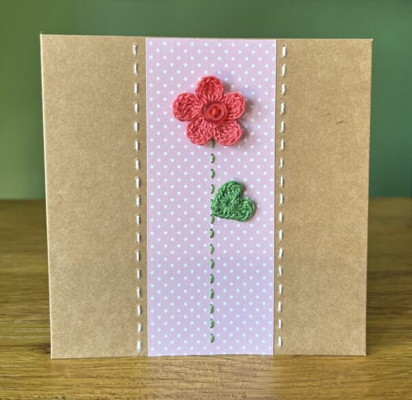 A single crocheted bright pink flower and green leaf, with a hand stitched detailing. This medium brown card has a blank white insert for your own message, and an envelope is included. Approximate size 12.5cm x 12.5 cm. Made using 100% cotton. Eco-friendly, Vegan friendly and fully recyclable.