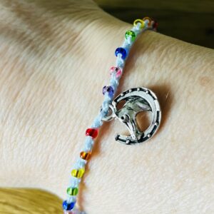 Single strand, fully adjustable bracelet with glass beads and silver metal coloured charm. Handmade using 100% cotton. Eco-friendly and fully recyclable.