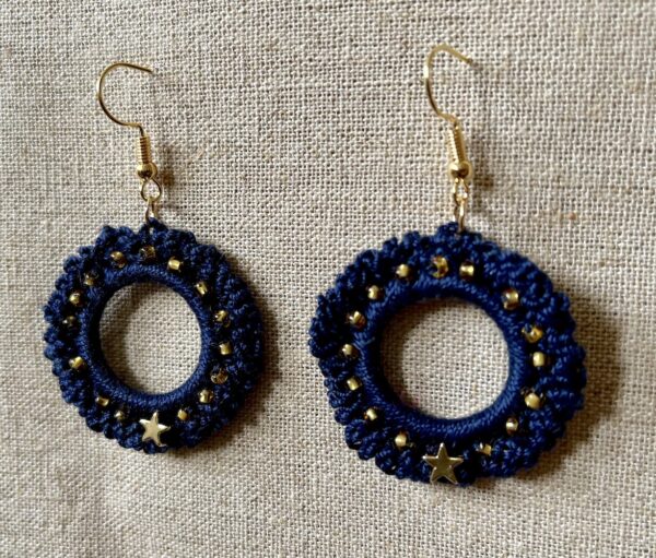 Hand made, crocheted, mini wreath earrings. Made using 100% cotton in a rich navy blue colour with a gold metal star and gold glass beading details. The earring hooks are made from a gold plated brass and are nickel, lead and cadmium free. Each earring measures approximately 3.5cm wide by 5.5cm Height (including hook).