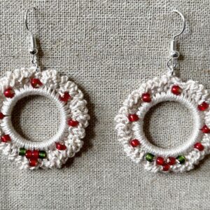 Hand made, crocheted, mini wreath earrings. Made using 100% cotton in natural cream colour with a mix of red and green glass beaded details. The earring hooks are made from a silver plated brass and are nickel, lead and cadmium free. Each earring measures approximately 3.5cm wide by 5.5cm Height (including hook).