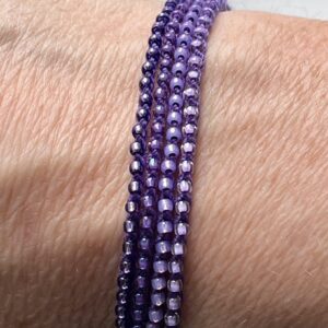 A handmade, crocheted and glass beaded bracelet. Fully adjustable with sliding metal bead fastening. 4 strands, made using 100% purple cotton and glass beads in 4 shades of purple.