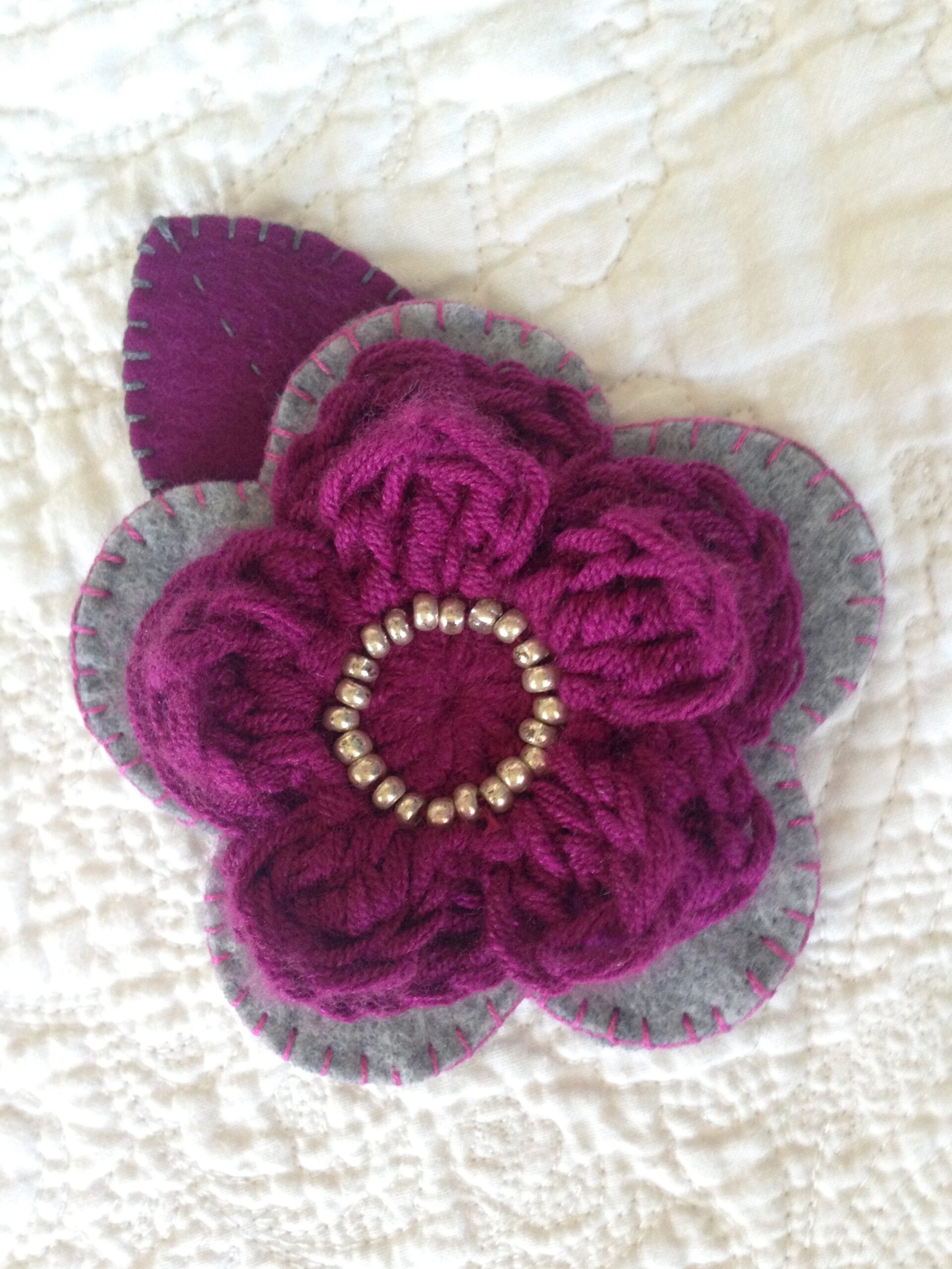 Hand sewn felt and beaded crocheted flower brooch.