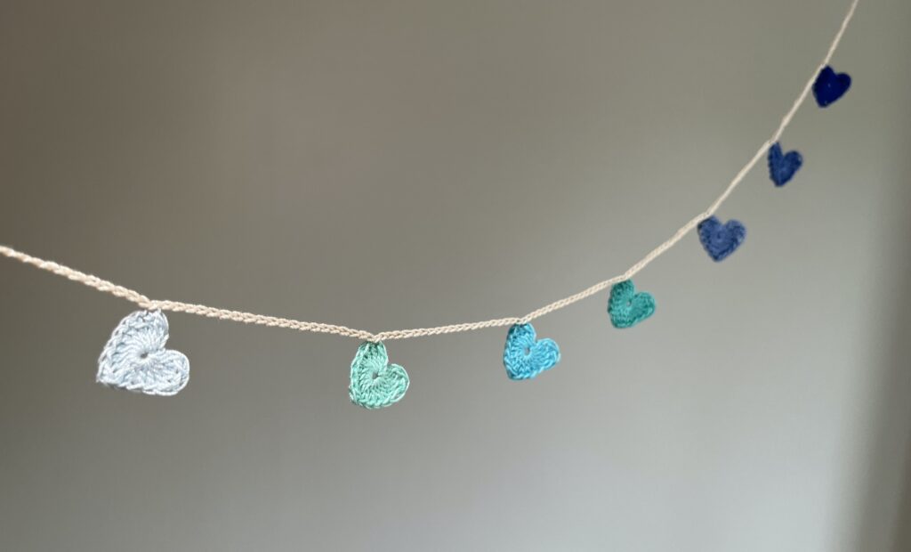 7 tiny crocheted hearts in a range of colours. They are  attached on a crocheted, natural cream cotton strand. Made in 100% cotton. Eco-friendly, vegan, recyclable, reusable. Total length approximately 67cm. Each heart measures approximately 2 x 2.5cm. 