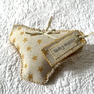 Gold star fabric, positive pants hanging decoration. A handmade, fabric and felt hanging decoration, with crocheted edging and ribbon bow, a positive pants label and hanging ribbon.