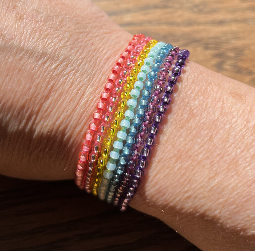 Rainbow, 7 strand, glass beaded bracelet. Fully adjustable. Made from 100% Cotton and glass beads with sliding metal bead fixing. Eco-friendly, Vegan Friendly and completely recyclable.