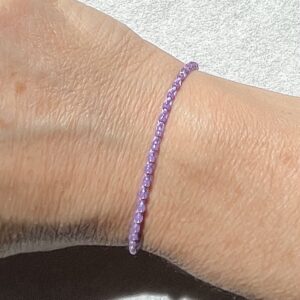 A handmade, crocheted, single stranded bracelet. Made using glass beads and 100% cotton both in a pastel purple/Lilac colour with a fully adjustable sliding bead fastening.