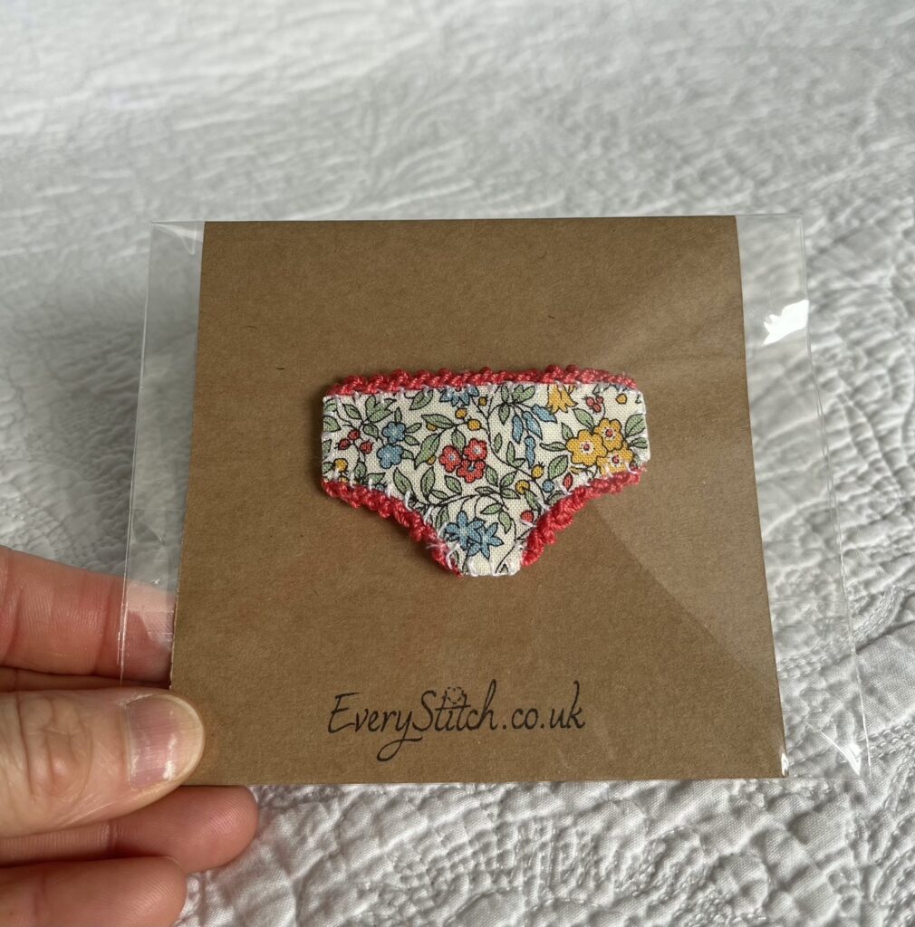 Handmade fabric and felt brooch with crocheted edging detail and a metal locking fastening. Approximate size 6cm Width x 4cm Height.