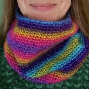 A handmade, close textured, crocheted neck warmer, made using a soft and lightweight acrylic yarn in a mix of bright rainbow inspired colours.
