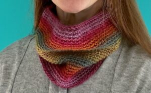 A handmade, close fitting, close textured, crocheted neck warmer, made using a soft and lightweight acrylic yarn in a mix of autumn rainbow inspired colours.
