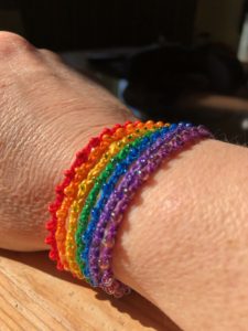 A multi stranded crocheted cotton and beaded adjustable bracelet in a rainbow of colours.