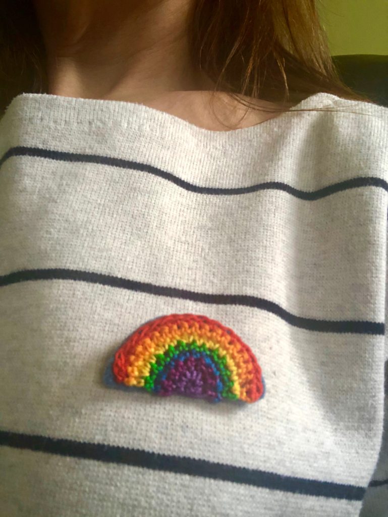 A small crocheted cotton rainbow brooch with hand sewn felt backing.