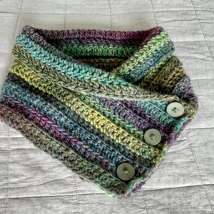 A soft and chunky textured wrap over style neck warmer, with button detail. Made using a chunky yet lightweight yarn that combines a mix of soft heather tones. This yarn is made of 80% acrylic, 20% Wool mix. The perfect winter warmer! It is machine washable on a wool cycle at 40 degrees. Gently reshape whilst wet. Do not wring or spin. Do not dry clean.