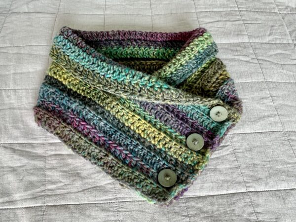 A soft and chunky textured wrap over style neck warmer, with button detail. Made using a chunky yet lightweight yarn that combines a mix of soft heather tones. This yarn is made of 80% acrylic, 20% Wool mix. The perfect winter warmer! It is machine washable on a wool cycle at 40 degrees. Gently reshape whilst wet. Do not wring or spin. Do not dry clean.