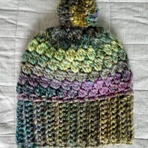 A soft and chunky textured hat with a large detachable bobble. Made in a subtle mix of heather tones. Made using a very soft and chunky, yet lightweight, 20% Wool/80% acrylic mix yarn. One size Adult.