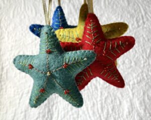 A handmade felt star hanging decoration. Medium size. Handmade in felt and hand sewn and embellished with glass beads and a gold hanging ribbon. Approximate size 9cm x 9cm (not including hanging ribbon) This is a decoration only, and is NOT a toy. Keep out of the reach of babies and small children due to the small parts.
