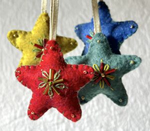 A handmade felt star hanging decoration. Small size. Handmade in felt and hand sewn and embellished with glass beads and a gold hanging ribbon. Approximate size 6cm x 6cm (not including hanging ribbon) This is a decoration only, and is NOT a toy. Keep out of the reach of babies and small children due to the small parts.