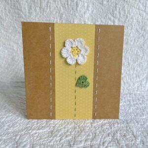 A single crocheted flower and leaf, with a hand stitched border. This small brown card has a blank white insert for your own message, and an envelope is included. Approximate size 10cm x 10 cm. Made using 100% cotton. Eco-friendly, Vegan friendly and fully recyclable.