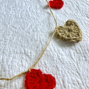 A garland of 9 individual hearts. x5 natural and x4 red. Hand crocheted and made in 100% jute. Approximate length 120cm.