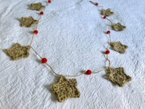 A garland of x8 individual stars and x9 felt pom-poms. Hand crocheted and made using 100% jute, and 100% wool for the felt pom-poms. Approximate length 190cm.