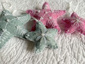 A handmade felt star hanging decoration. Small size. Handmade in felt and hand sewn and embellished with glass beads and a hanging ribbon. Approximate size 6cm x 6cm (not including hanging ribbon) This is a decoration only, and is NOT a toy. Keep out of the reach of babies and small children due to the small parts.