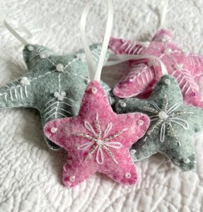 A handmade felt star hanging decoration. Small size. Handmade in felt and hand sewn and embellished with glass beads and a hanging ribbon. Approximate size 6cm x 6cm (not including hanging ribbon) This is a decoration only, and is NOT a toy. Keep out of the reach of babies and small children due to the small parts.